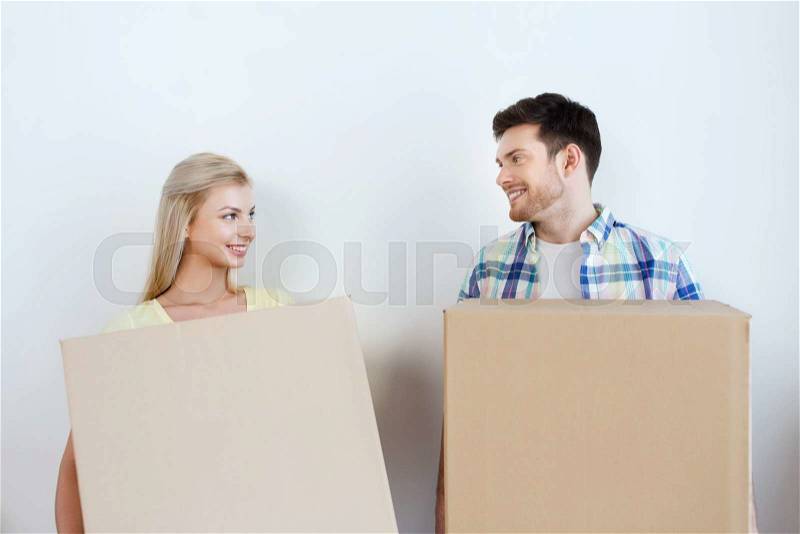 Home, people, repair and real estate concept - smiling couple with big cardboard boxes moving to new place, stock photo