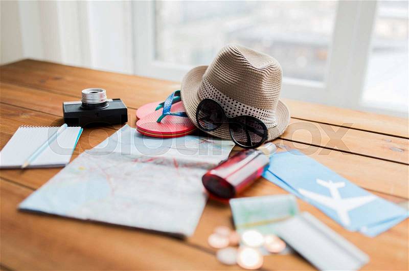 Summer vacation, tourism and objects concept - close up of travel map, airplane tickets, money and personal accessories, stock photo