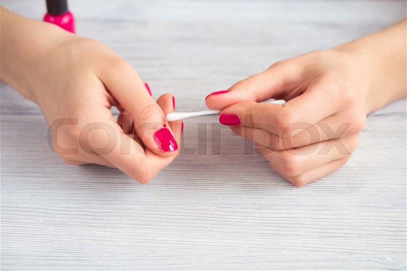 Female hand cleaned incorrect applied varnish during a manicure, stock photo