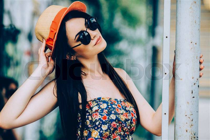 Beautiful girl in sunglasses posing for the camera in the city, stock photo