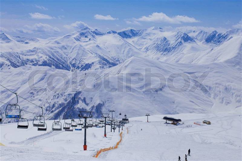 Panoramic view on ski station on snowy mountains background, stock photo