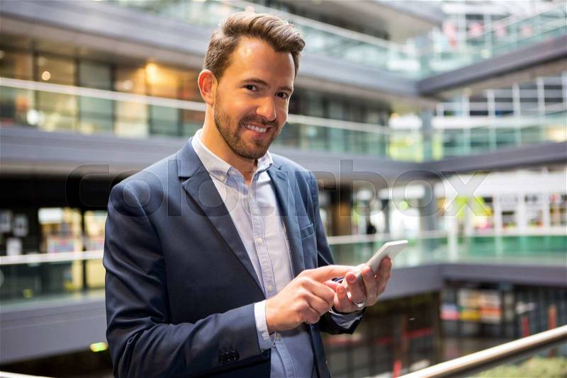 View of a Young attractive business man using smartphone, stock photo