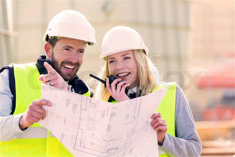 View of Workers on a construction studying blueprints, stock photo