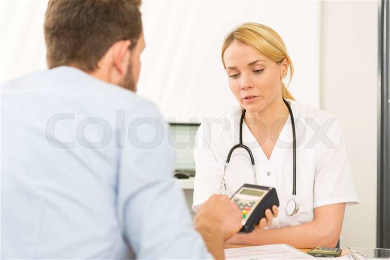 View of a Patient paying the doctor by credit card, stock photo