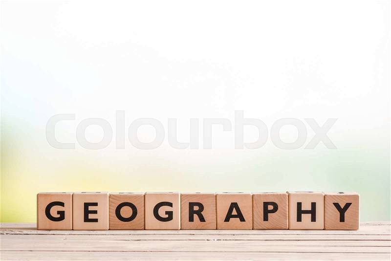 Geography lesson sign made of cubes on a wooden desk, stock photo
