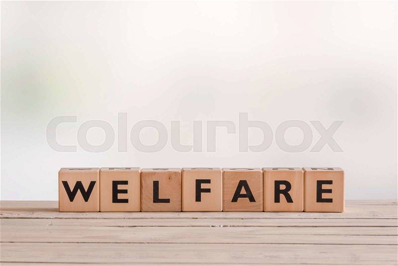 Welfare sign made of wooden cubes on a desk, stock photo