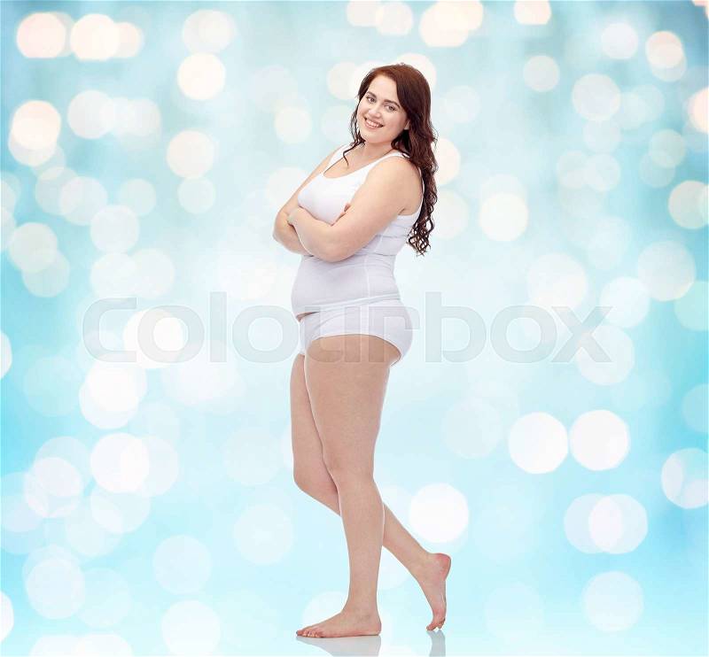 Plus size and people concept - happy plus size woman in underwear background over blue holidays lights background, stock photo