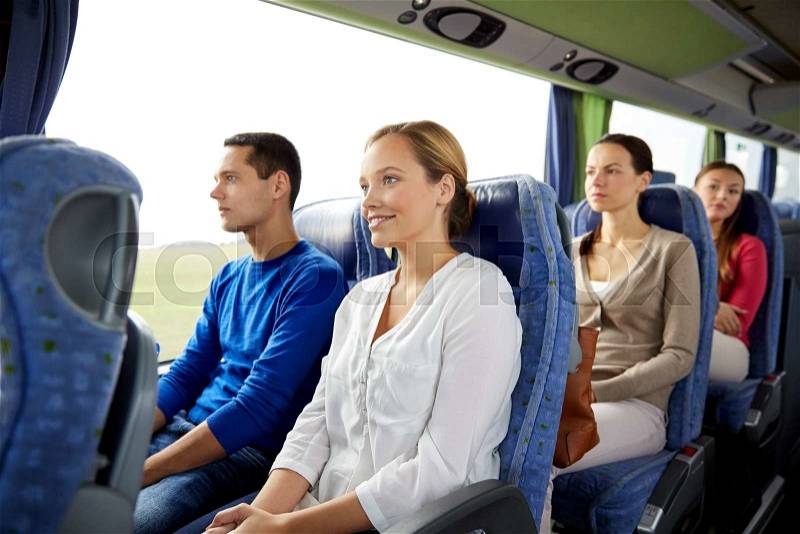 Transport, tourism, road trip and people concept - group of happy passengers or tourists in travel bus, stock photo