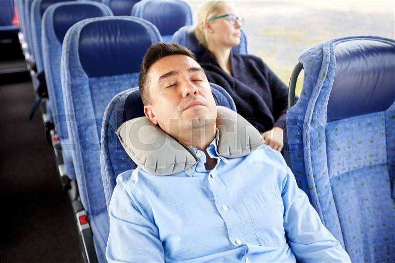 Transport, tourism, rest , comfort and people concept - man sleeping in travel bus with cervical neck inflatable pillow, stock photo