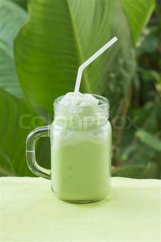 Matcha Green Tea smoothie for refreshment on garden background, stock photo
