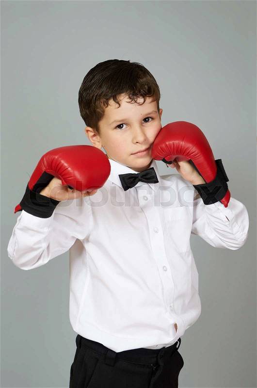 Five years old boy in white shirt and bow tie with boxing\\karate gloves on the hands, stock photo