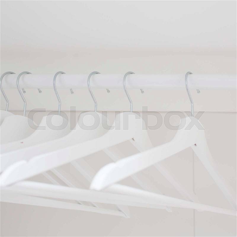 Wooden coat hangers on clothes rail, stock photo