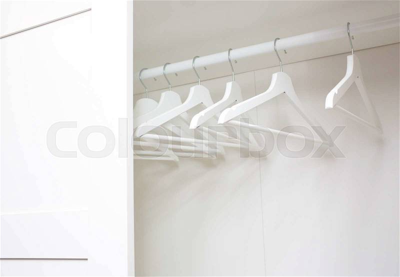Wooden coat hangers on clothes rail, stock photo