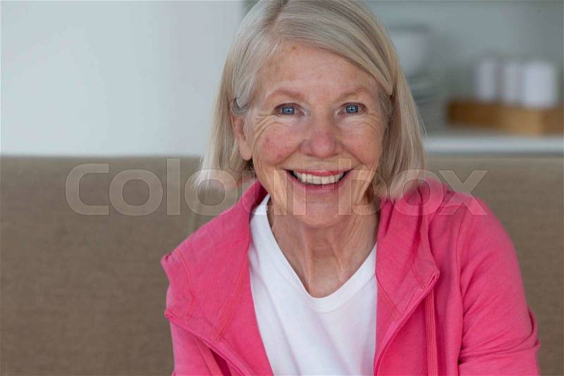 Portrait of a senior woman. She is smiling and looking at the camera, stock photo