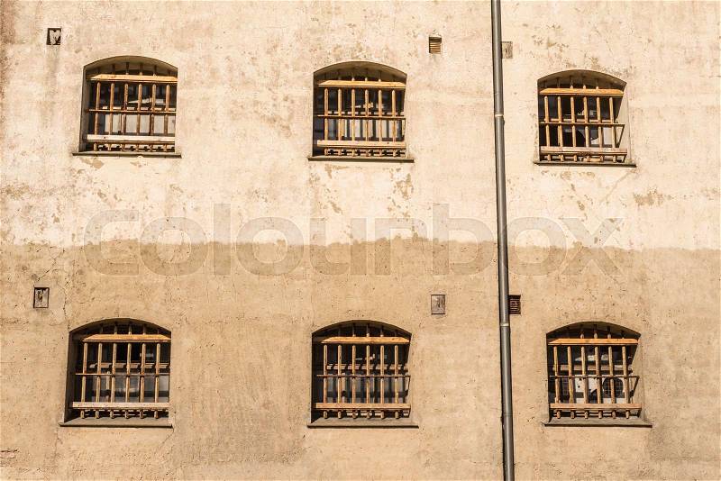 Jail wall with windows with bars on a wall, stock photo