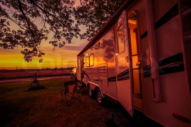 Travel Trailer Camping Spot at Scenic Sunset. Camper Traveling. Pulling Travel Trailer by Car, stock photo