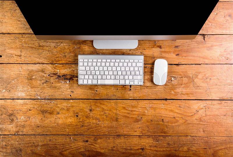 Computer, keyboard and mouse layid on wooden office desk. Flat lay. Copy space, stock photo