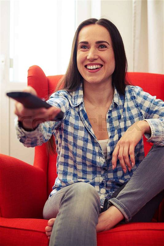 Excited woman watching tv at home, stock photo