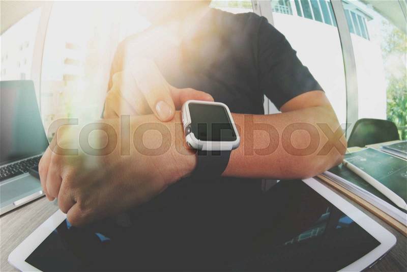 Website designer working with smart watch and digital tablet and digital design diagram on wooden desk as concept , stock photo