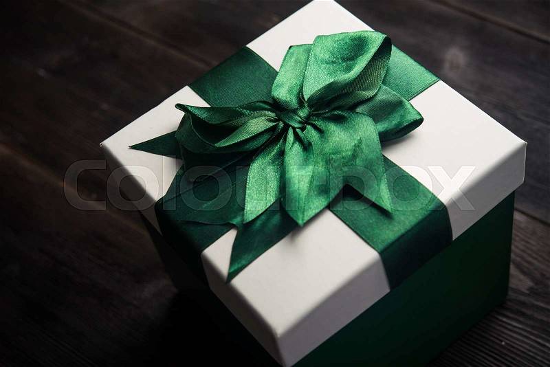 White gift box with green ribbon bow, stock photo