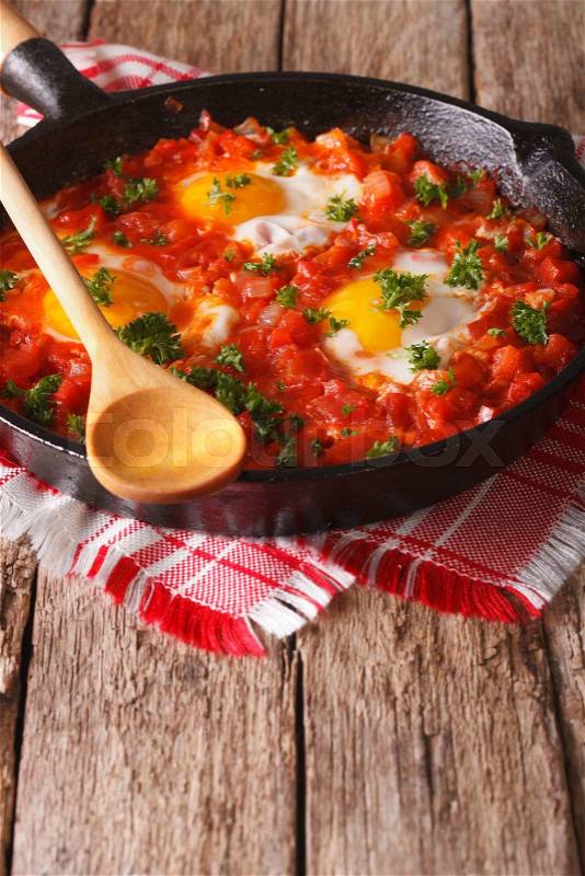 Fried egg in tomato sauce in the pan on the table. vertical\, stock photo