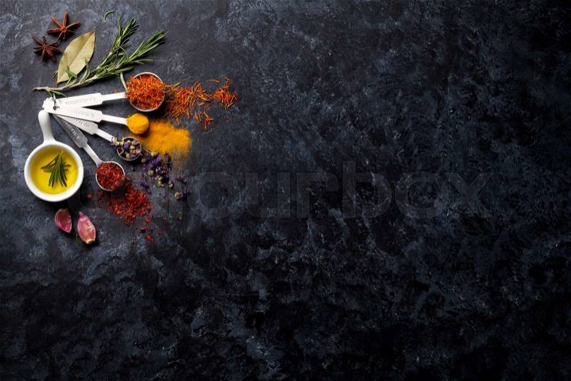 Herbs and spices over black stone background. Top view with copy space, stock photo