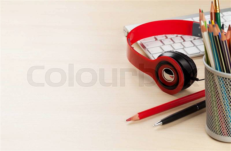 Office desk with headphones and supplies. View with copy space, stock photo
