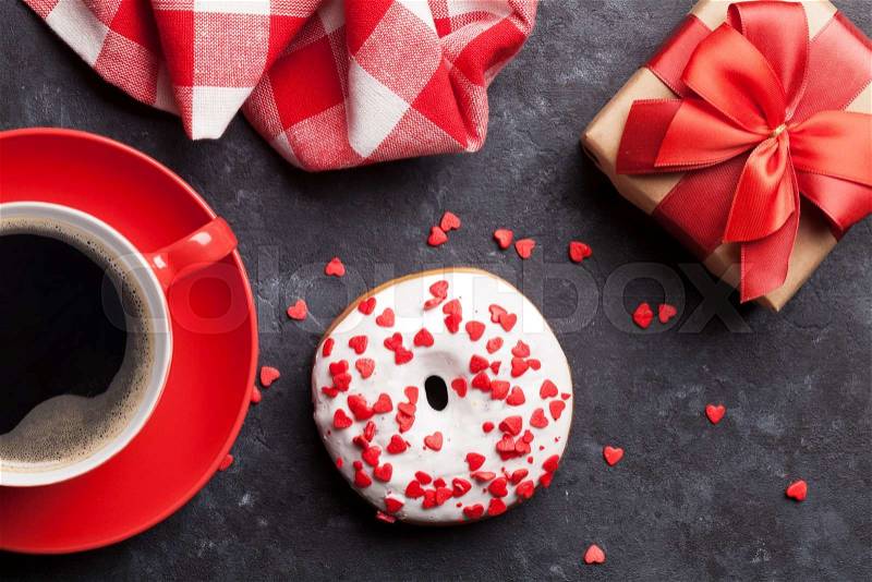 Donut, coffee and gift box on stone table. Top view, stock photo