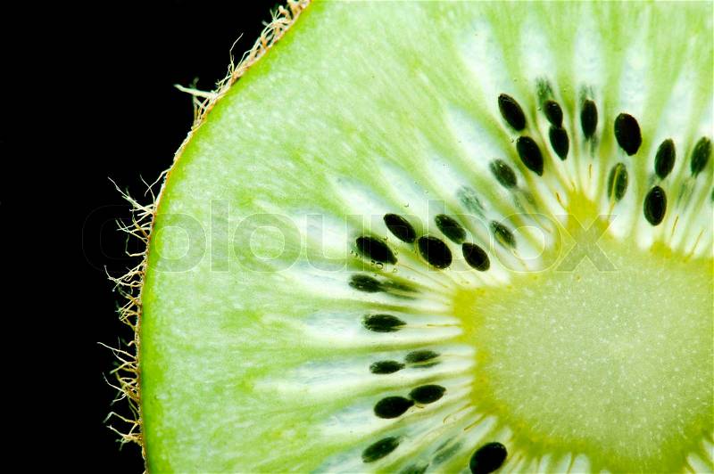 Macro of slim sliced kiwi fruit on black background, stock photo