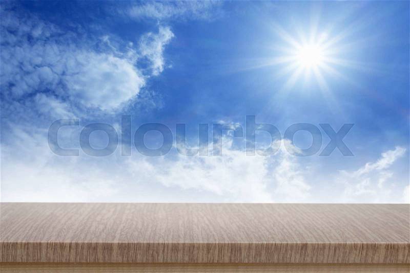 Empty top of wooden table or counter and blured image of blue sky. For product display, stock photo