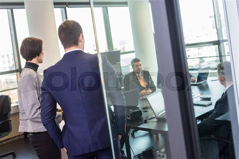 Successful team leader and business owner leading in-house business meeting, explaining business plans to his employees. Business and entrepreneurship concept, stock photo