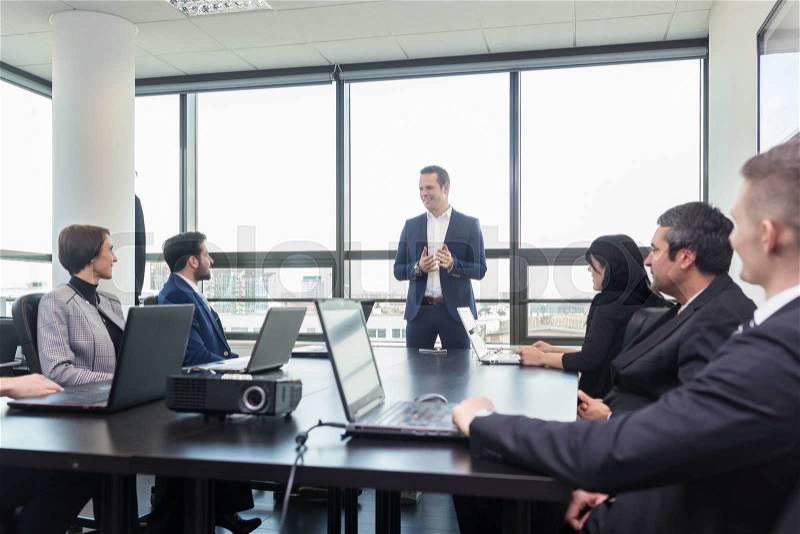 Successful team leader and business owner leading in-house business meeting, explaining business plans to his employees. Business and entrepreneurship concept, stock photo