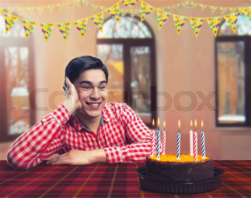 Happy birthday boy with cake in decorated room, stock photo
