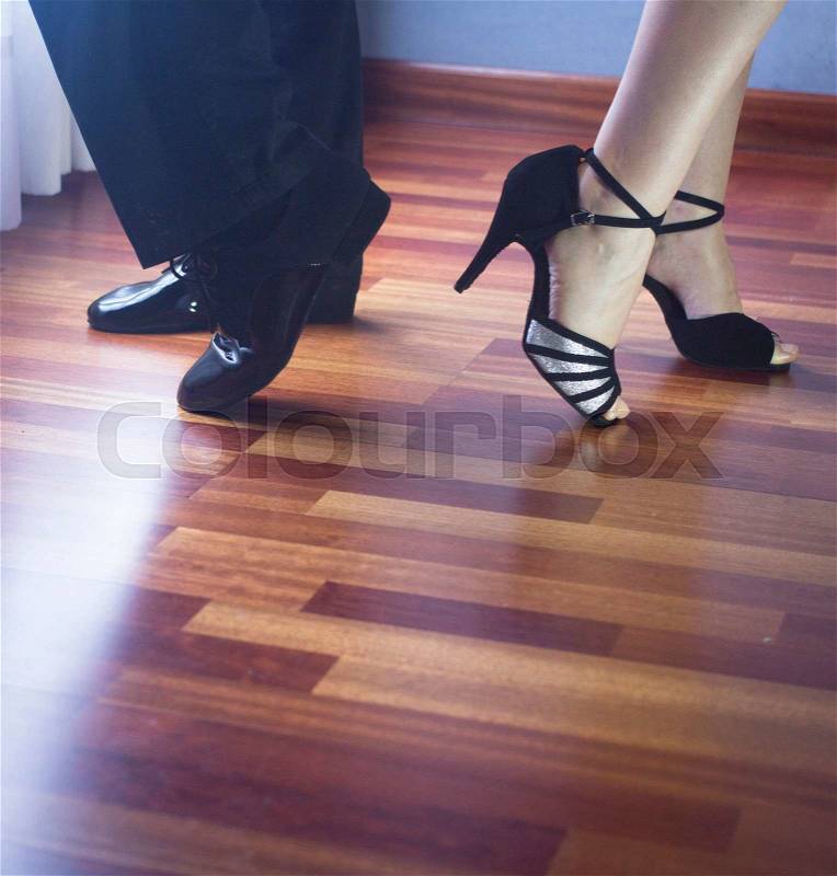 Male and female ballroom, standard, sport dance, latin and salsa couple dancers feet and shoes in dance academy school rehearsal room dancing modern contemporary style, stock photo
