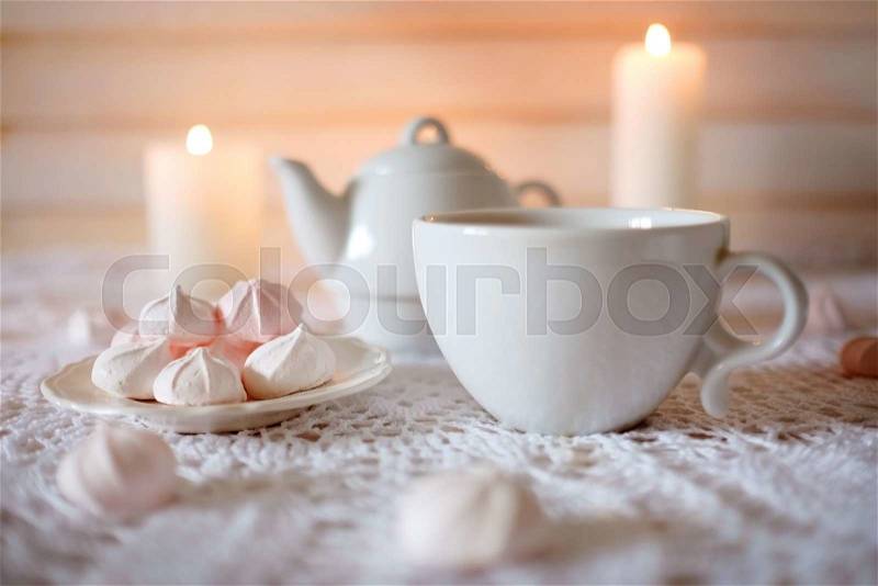 Tea time. Lunch with hot tea, candles and diet dessert white and pink marshmallows, stock photo