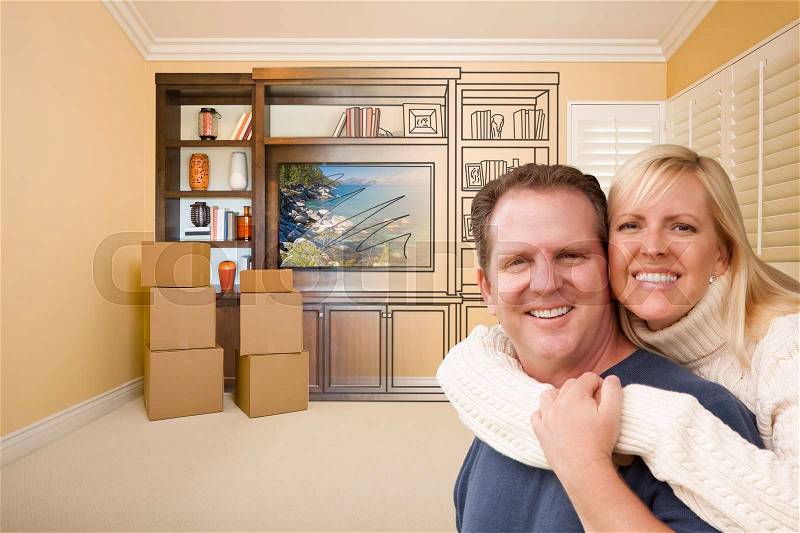 Young Couple In Room With Moving Boxes and Drawing of Entertainment Unit On Wall, stock photo