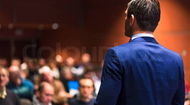 Speaker giving a talk on corporate Business Conference. Audience at the conference hall. Business and Entrepreneurship event, stock photo