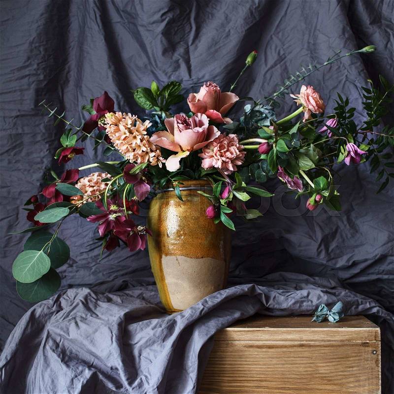 Flower in the vase on the table on the background of gray fabric, stock photo