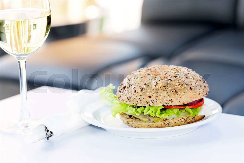 Restaurant burger with white wine on table, stock photo
