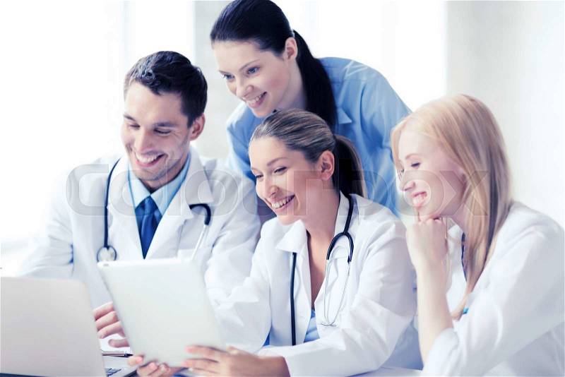 Healthcare, medical and technology concept - group of doctors looking at tablet pc, stock photo