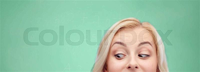 Curiosity, education, advertisement and people concept - happy young woman or teenage girl face over green school chalk board background, stock photo
