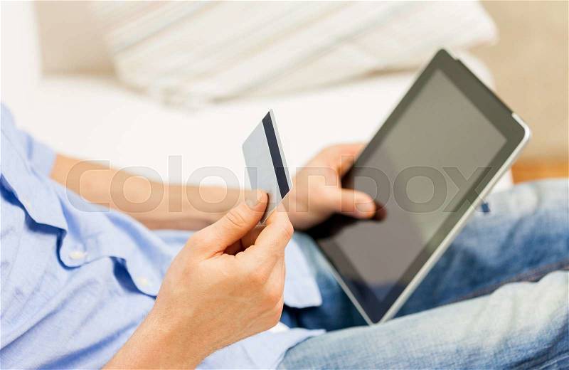 Technology, people, online shopping, banking and lifestyle concept - close up of man with tablet pc computer and credit or bank card at home, stock photo