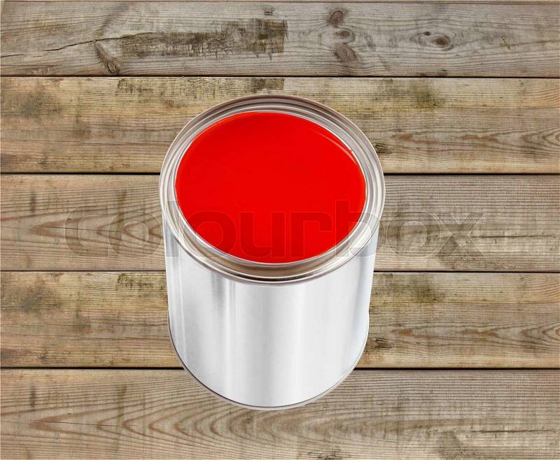 Open tin can with red paint on wooden table background, stock photo