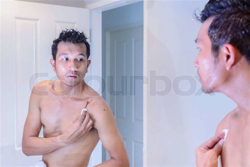 Man cleaning after hair coloring by oneself with a mirror, stock photo