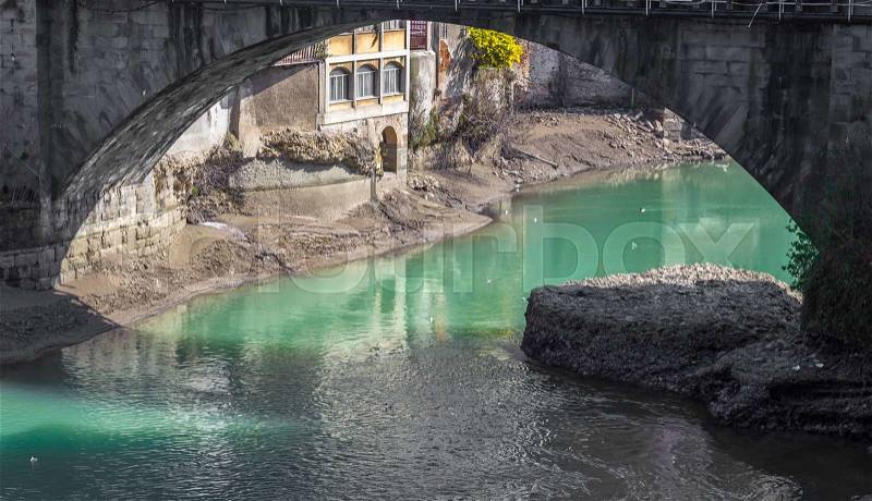Some buildings along the river seen from under the bridge in an old italian town, stock photo