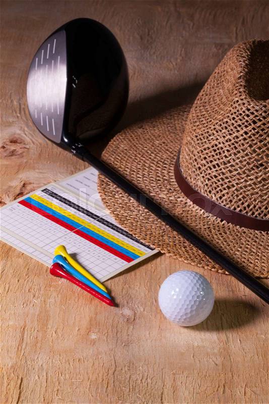 Siesta - straw hat and golf driver on a wooden table, stock photo