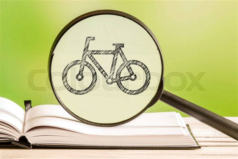 Bike search with a pencil drawing of bicycle in a magnifying glass, stock photo