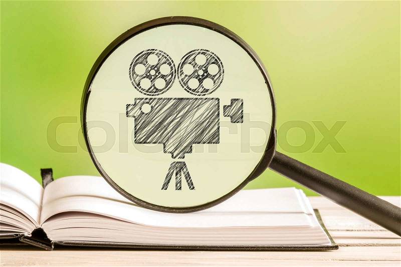 Movie search with a pencil drawing of a movie projector in a magnifying glass, stock photo