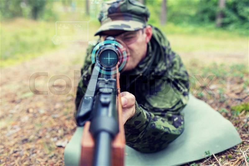 Hunting, war, army, technology and people concept - close up of young soldier or sniper holding gun with virtual screen projection and aiming in forest, stock photo