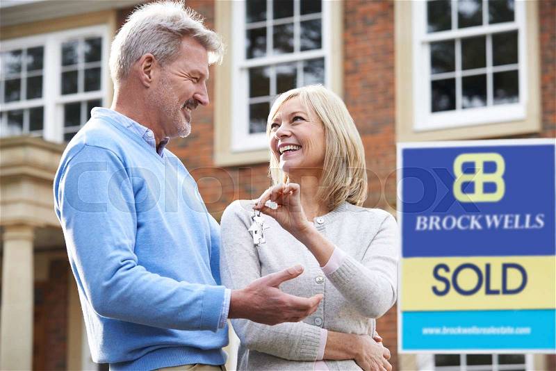 Mature Couple Happy At Getting Keys To New House, stock photo